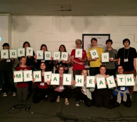 teens holding sign saying hashtag get loud for mental health