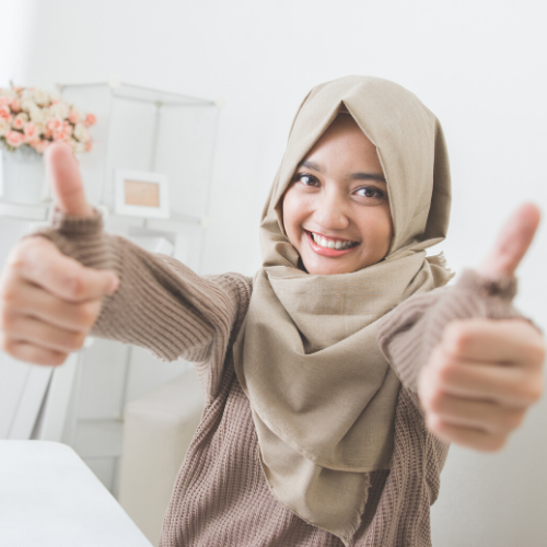 girl smiling and giving thumbs up