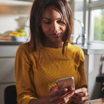 woman checking phone in her kitchen